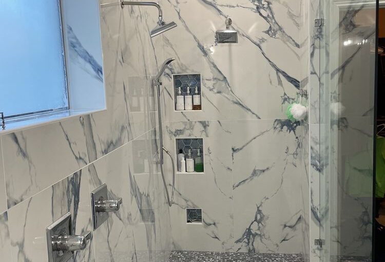 Frisco TX master bathroom shower renovation with frameless glass and full tile surround Collin County tile shower installation with dual shower heads and custom niche shelving Frisco TX bathroom remodel featuring marble tile shower walls and pebble shower pan